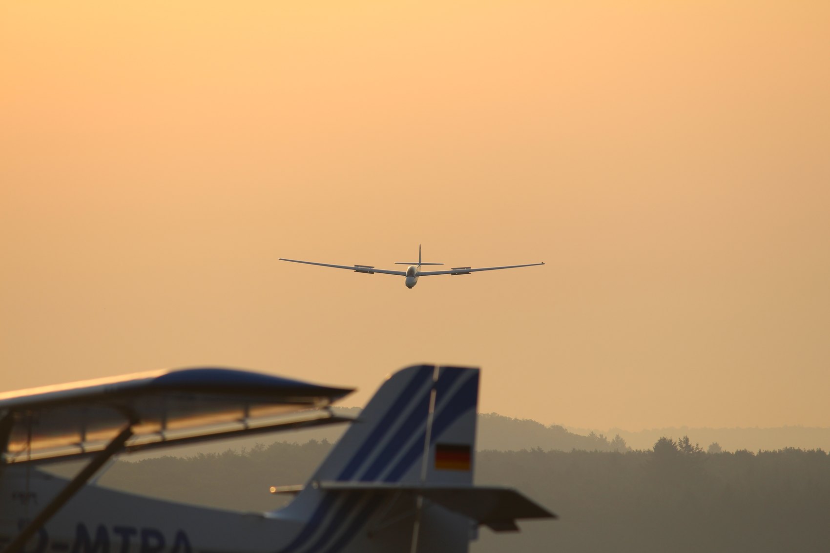 Die ASK 13 im Schlepp über dem Flugplatz Braunfels im Abendlicht